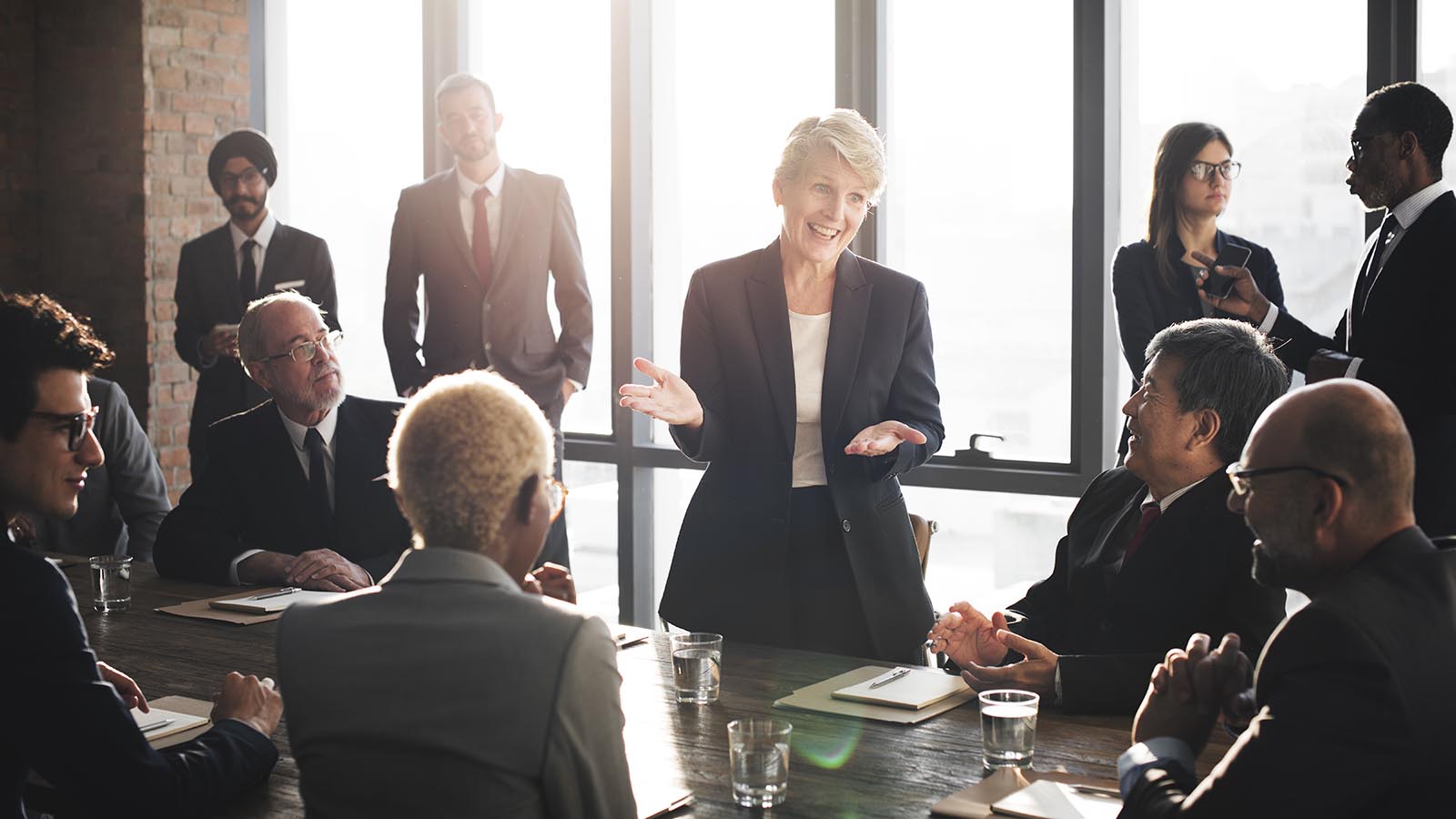 Image of a group of business individuals talking to one another standing up.