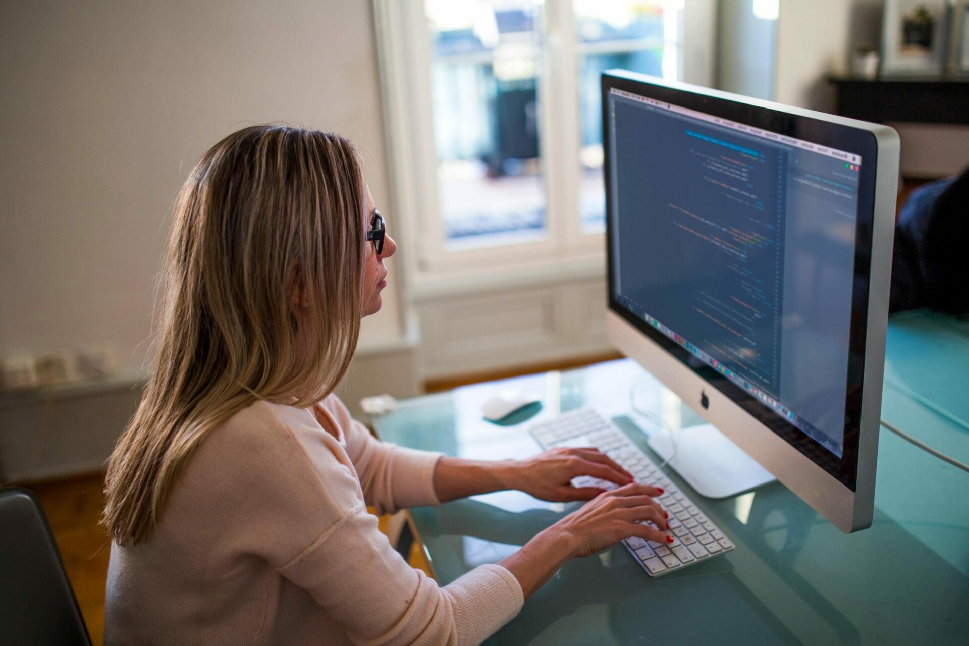 Image of a woman sitting at her computer working in a room.