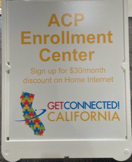 Picture of a sign that reads "ACP Enrollment Center, sign up for $30 / month discount on home internet, Get Connected California."